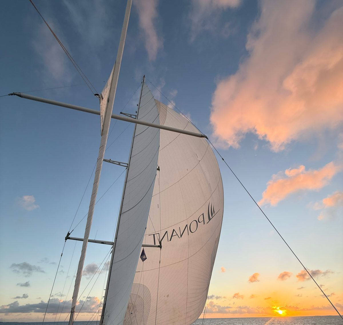Sunset behind the Ponant spinnaker, seen from the deck
